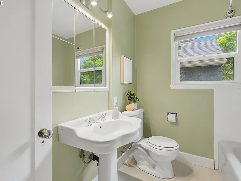 Bathroom with green walls and pedestal sink