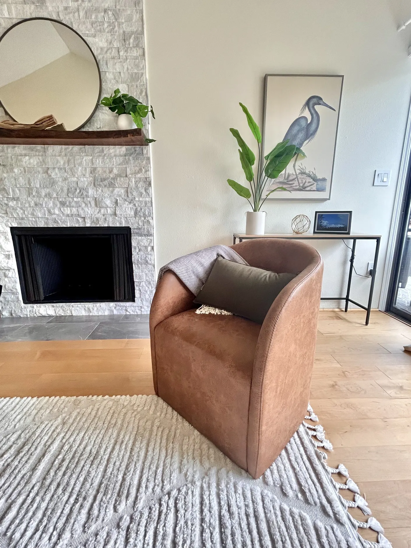 Living room chair beside stone fireplace