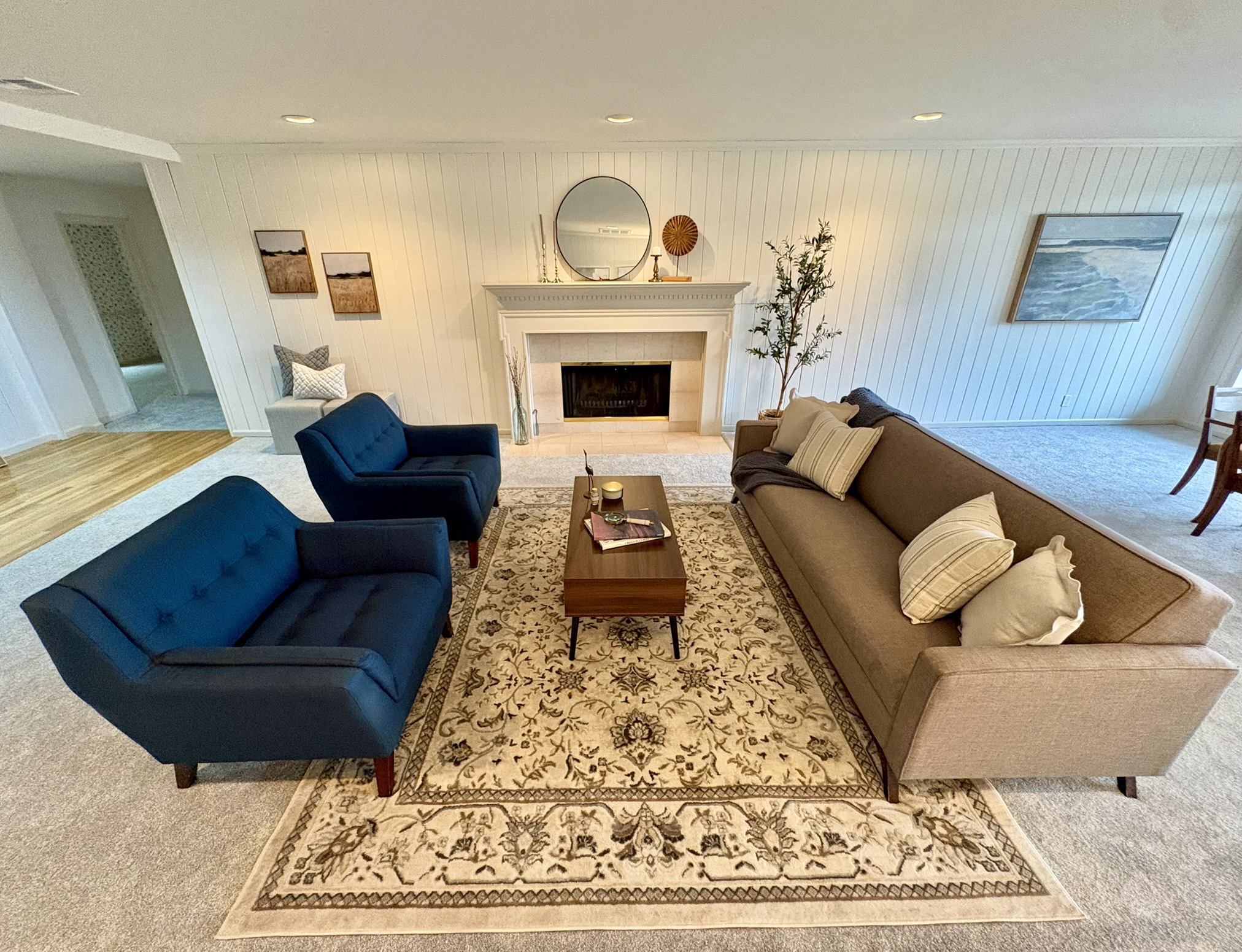 Living room arrangement with blue armchairs, sofa and fireplace