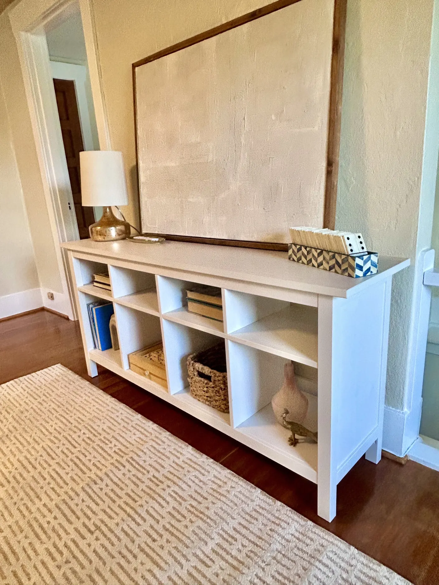 White console with abstract artwork and styled accessories
