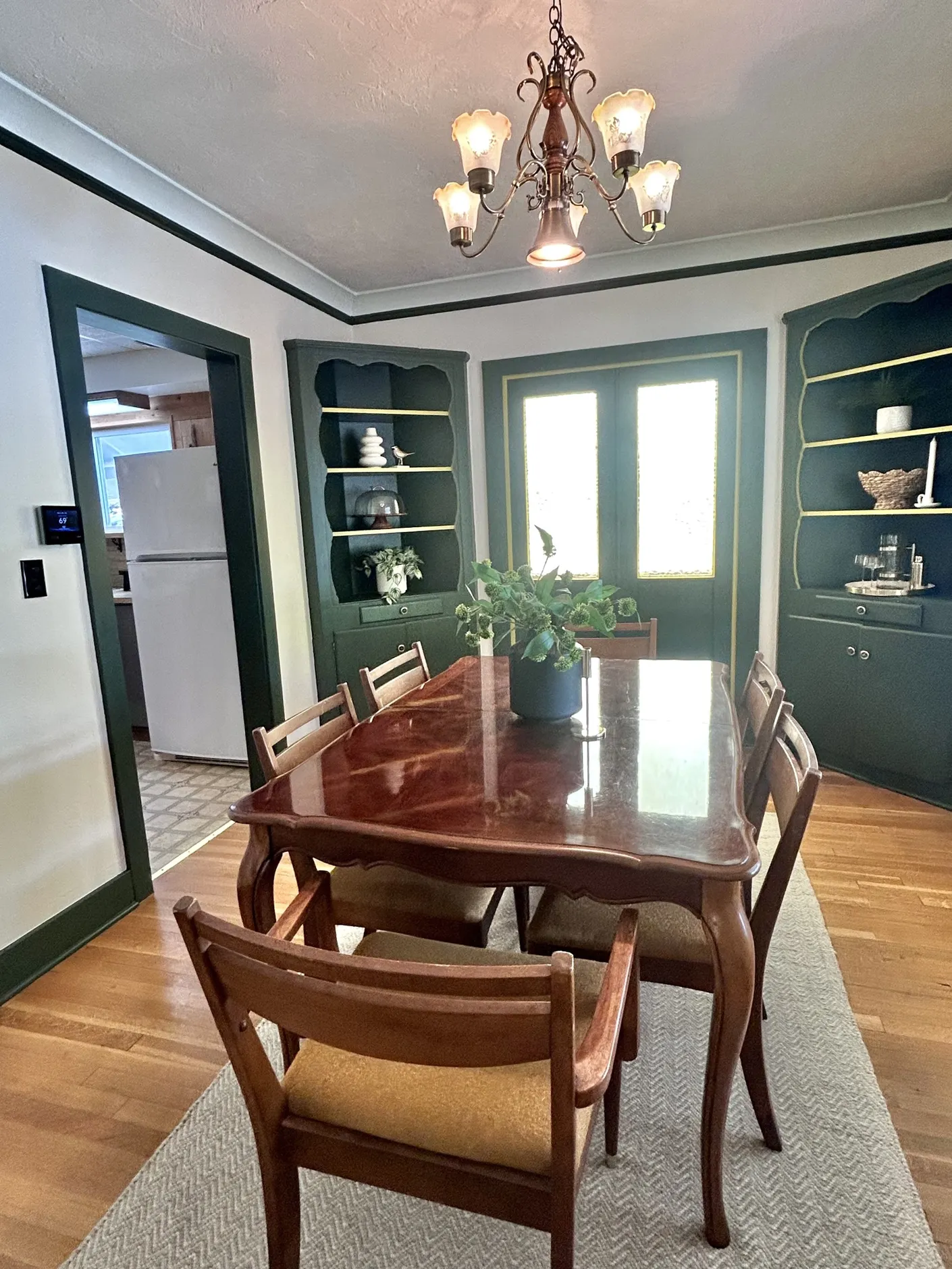 Dining room with wood table and deep green built-ins