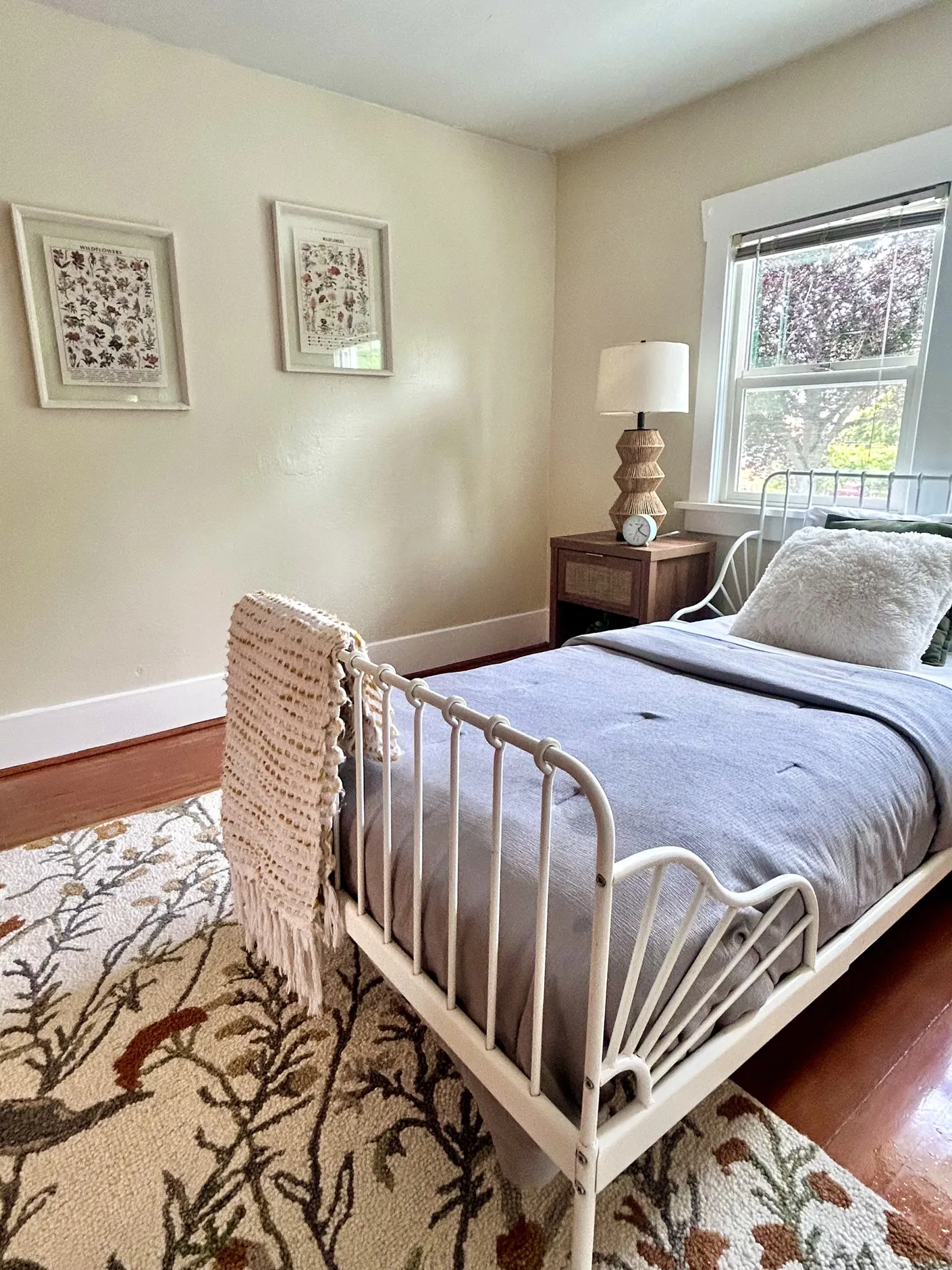 Closer view of the guest bedroom with white metal bed