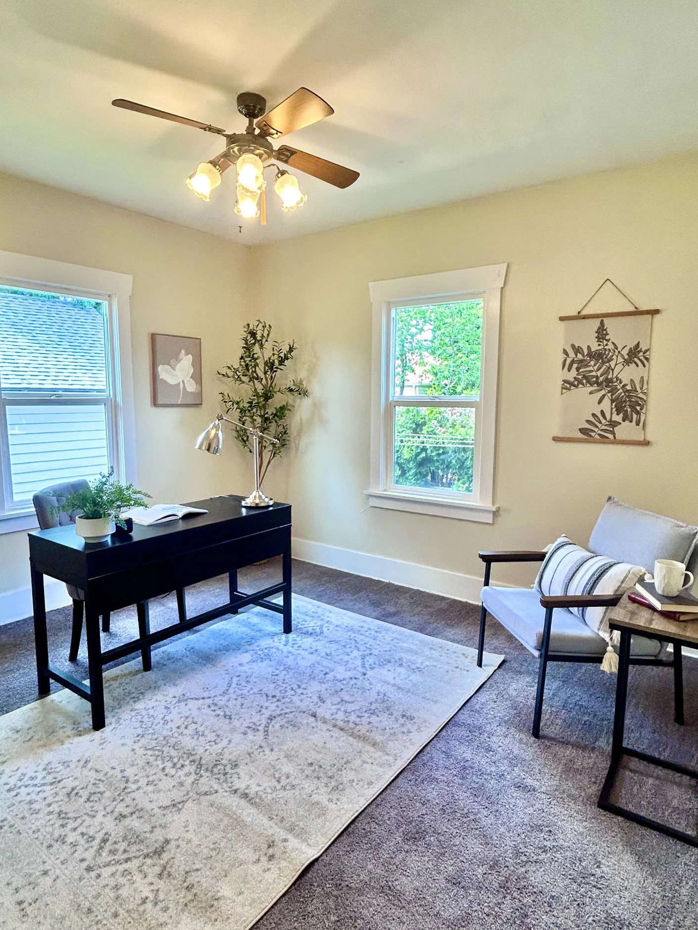 Home office with desk, reading chair, and leafy view