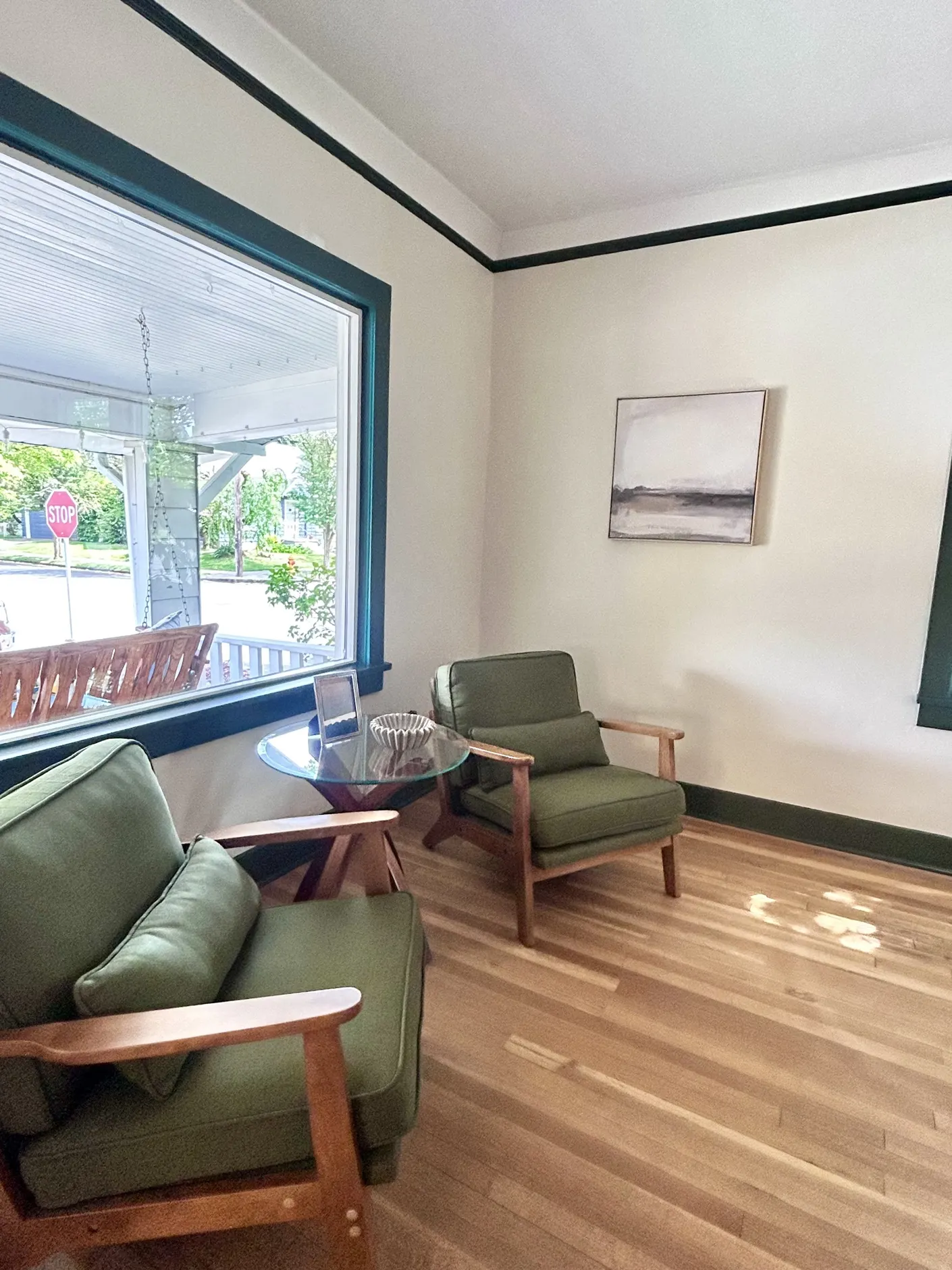 Sitting room with two green chairs and a round table