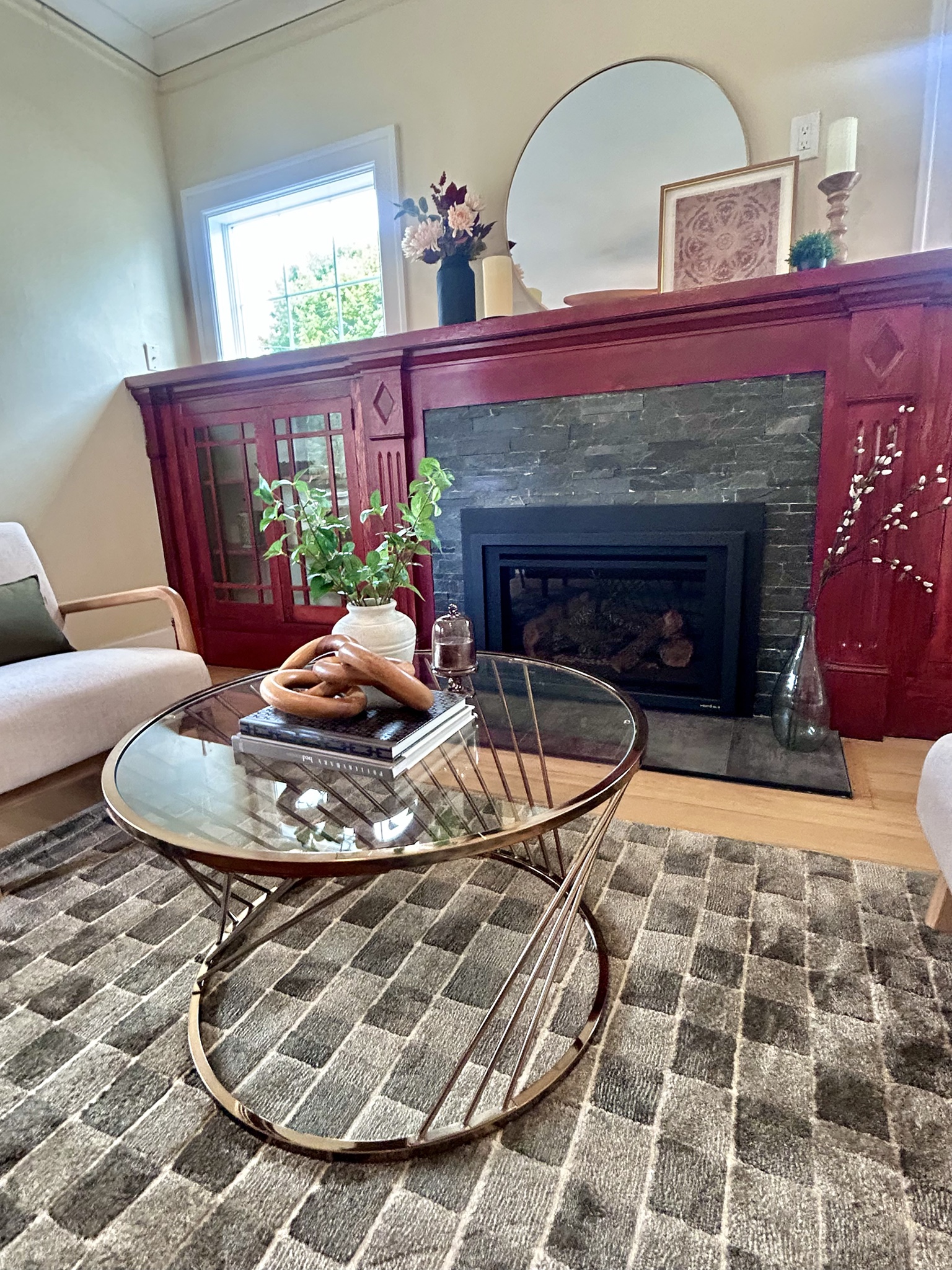Living room with a red fireplace surround and round glass coffee table
