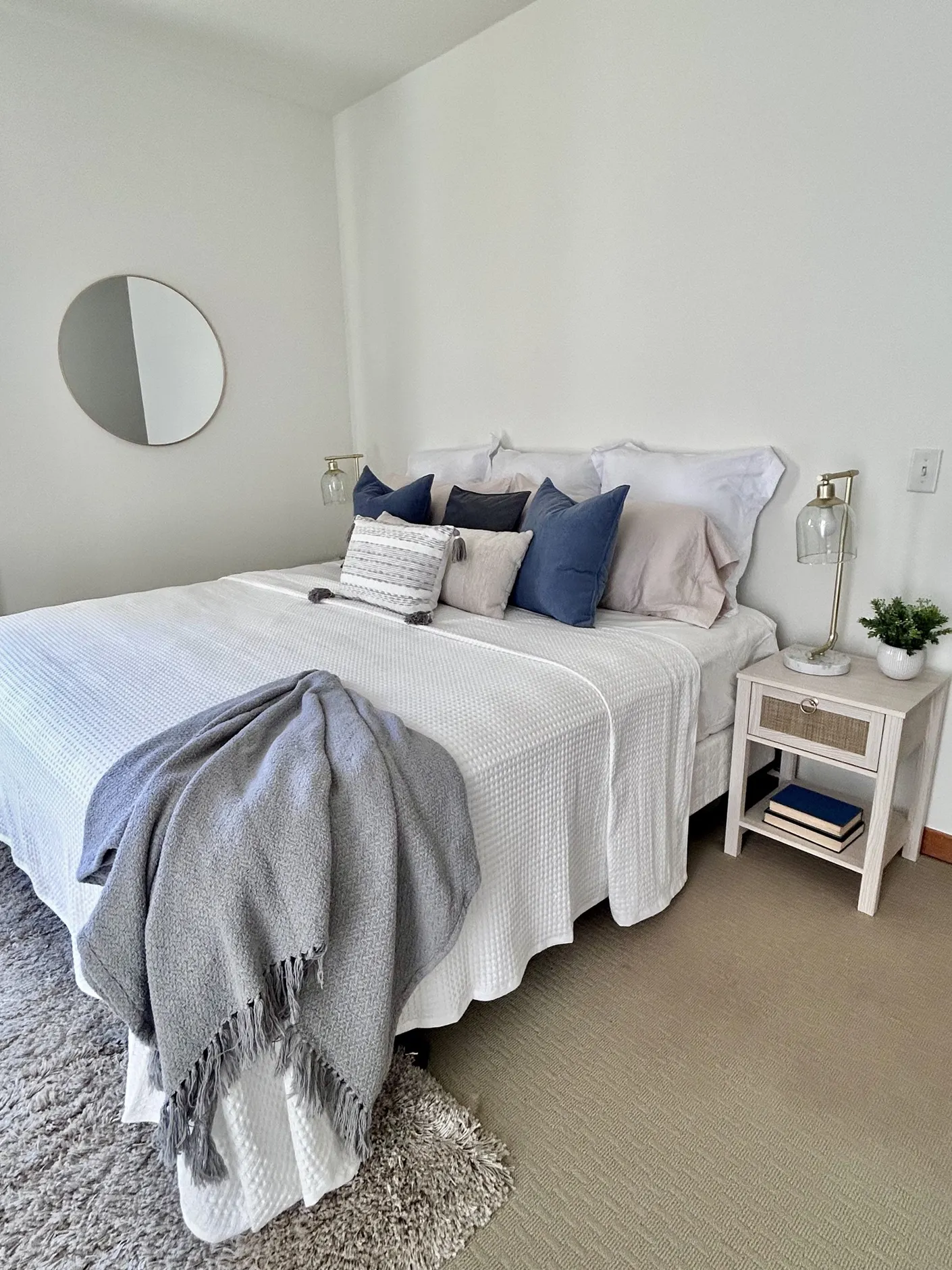 Bedroom with layered white bedding and blue pillows