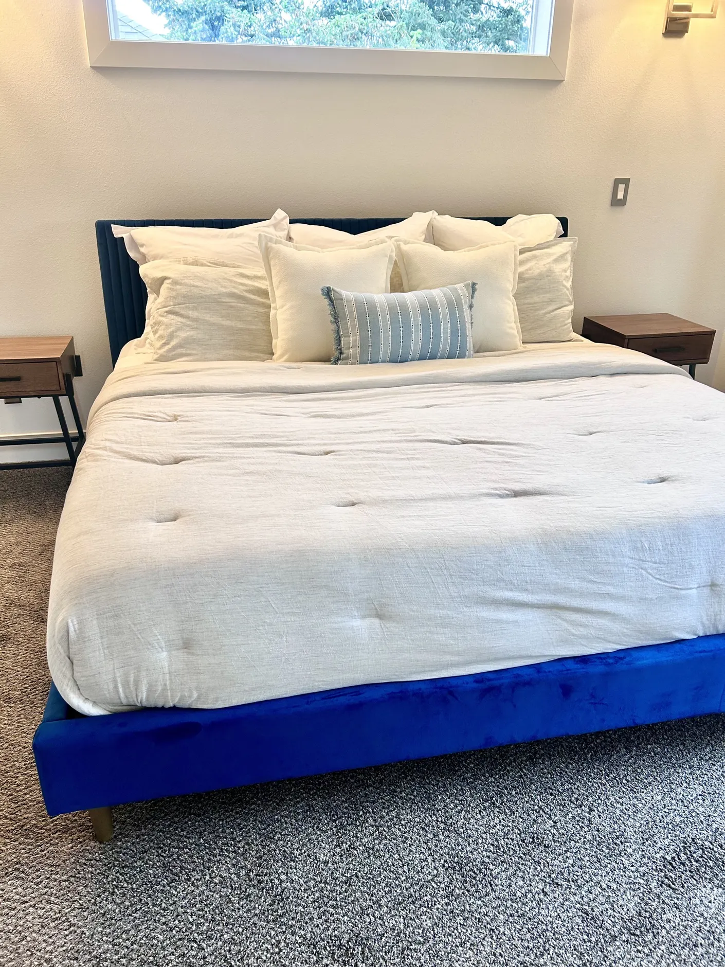 Bedroom with white bedding and a blue upholstered bed