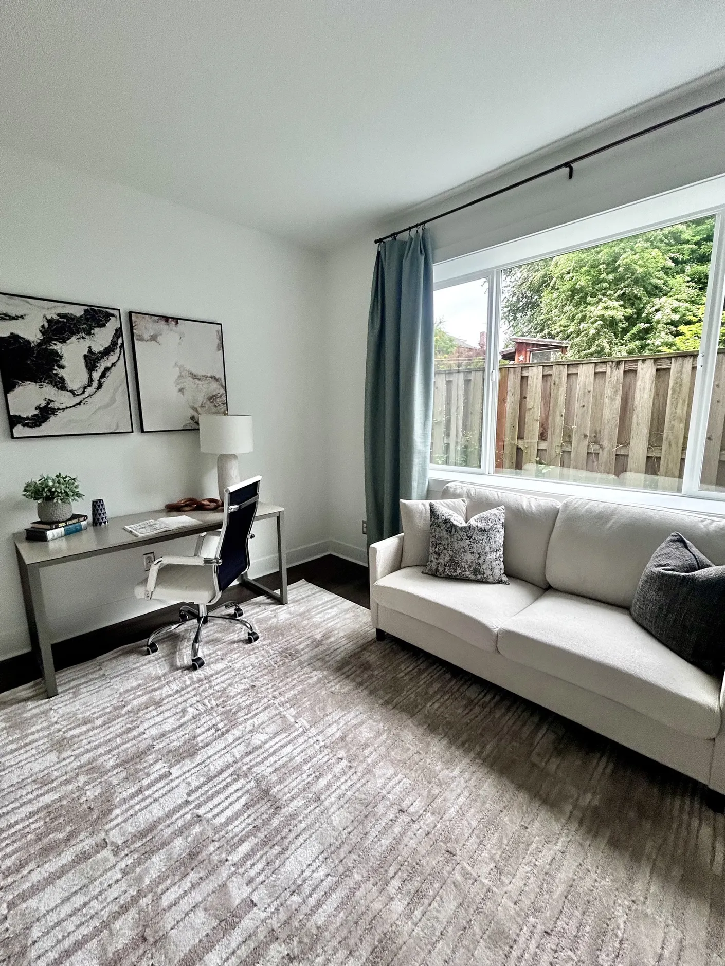 Home office with desk and cream sofa by the window