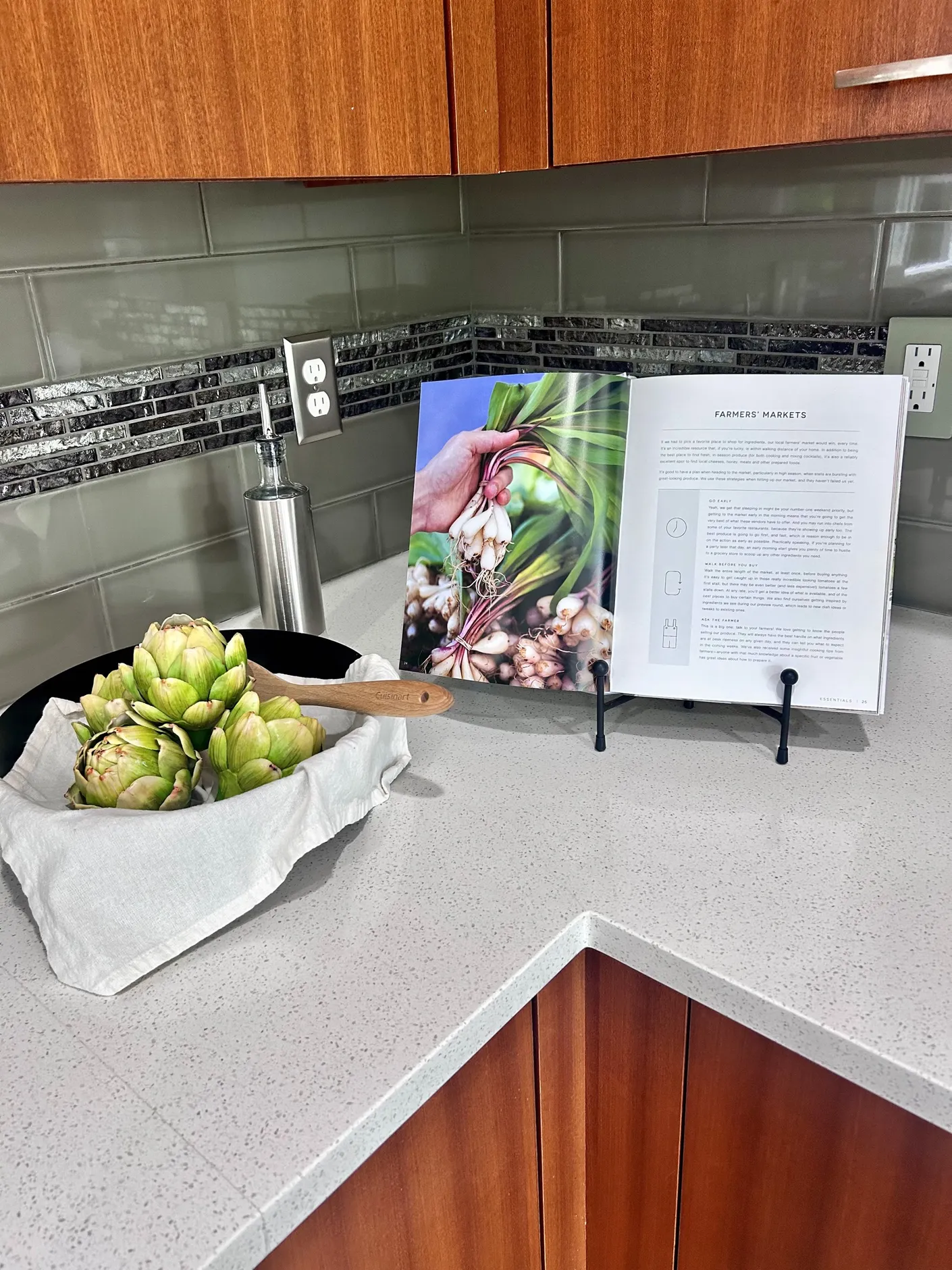 Artichokes and cookbook styled on the kitchen counter