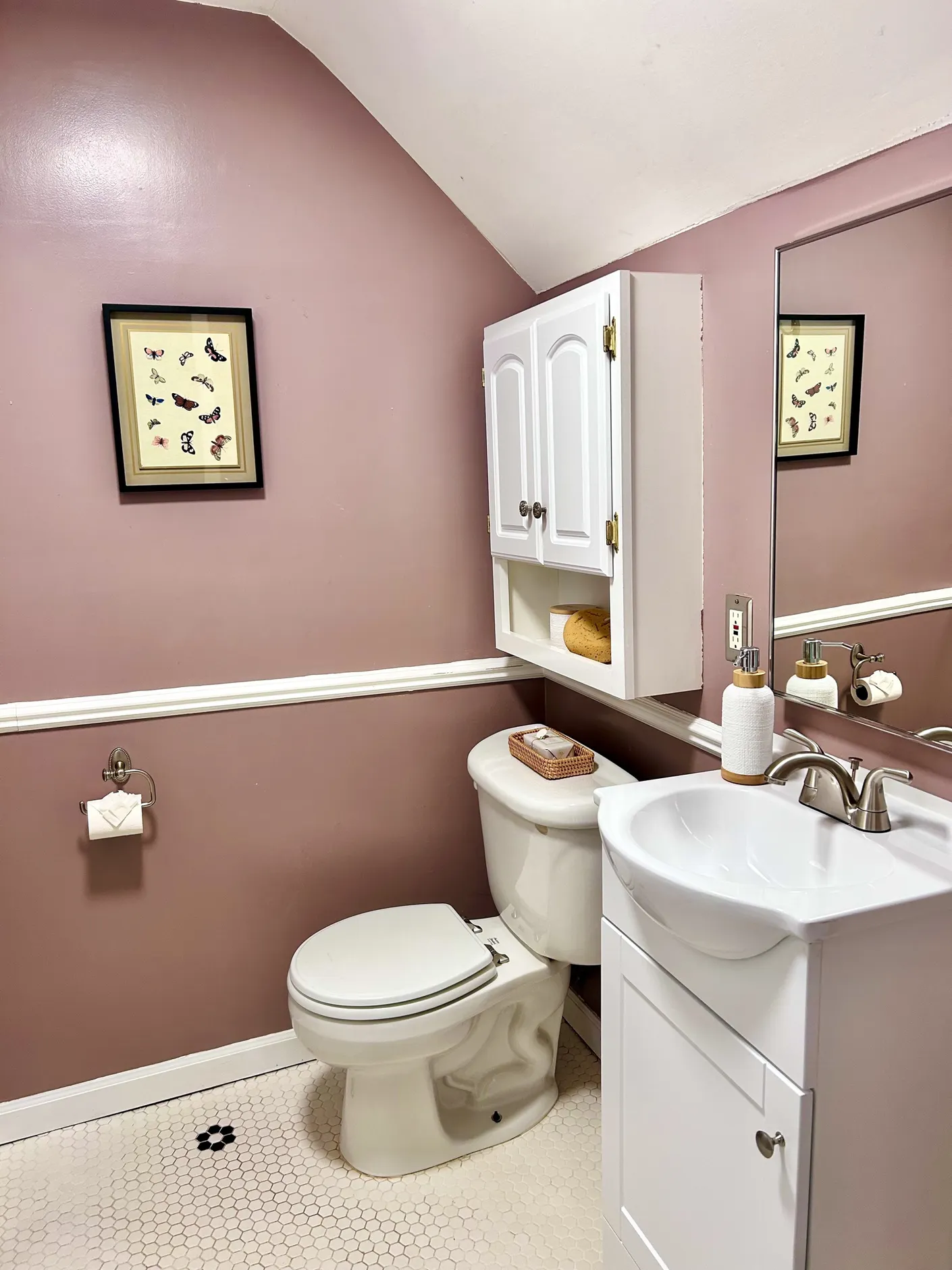 Bathroom with rose-colored walls and white vanity