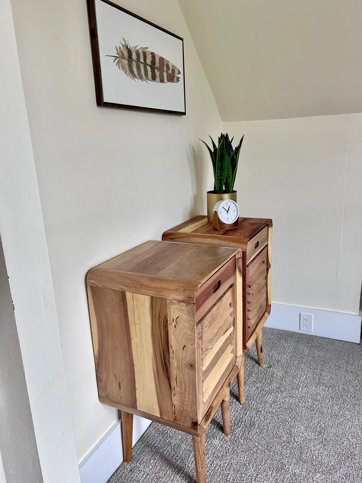 Pair of wood dressers beneath framed botanical artwork