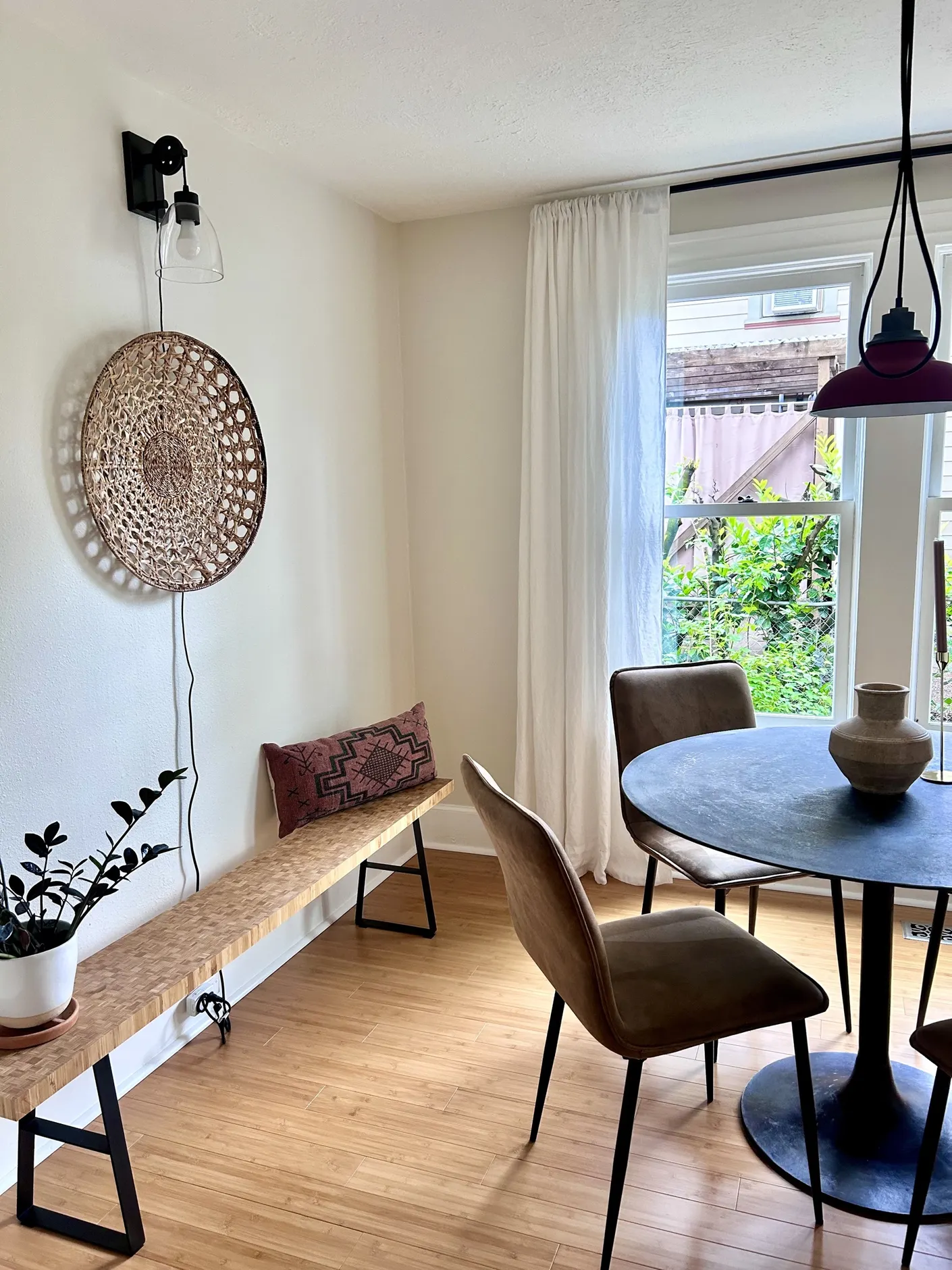 Dining nook with round table and woven bench
