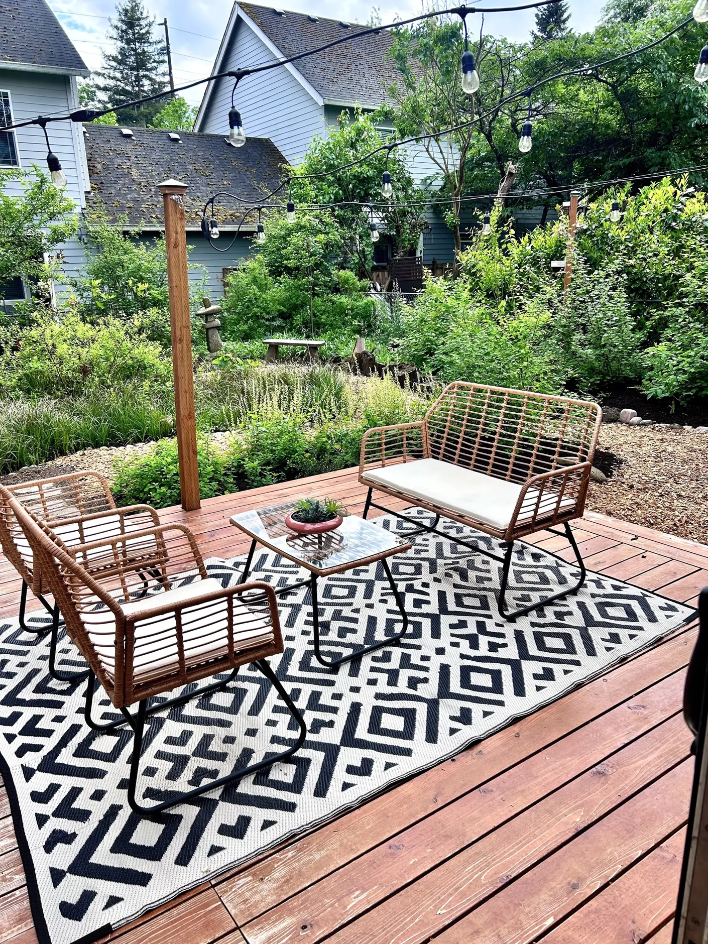 Garden deck with wicker seating and patterned rug