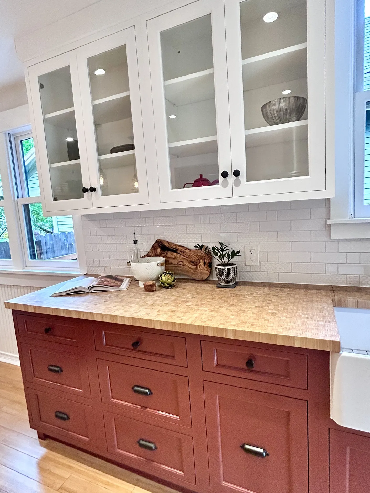 Kitchen counter with red cabinets and glass-front cupboards