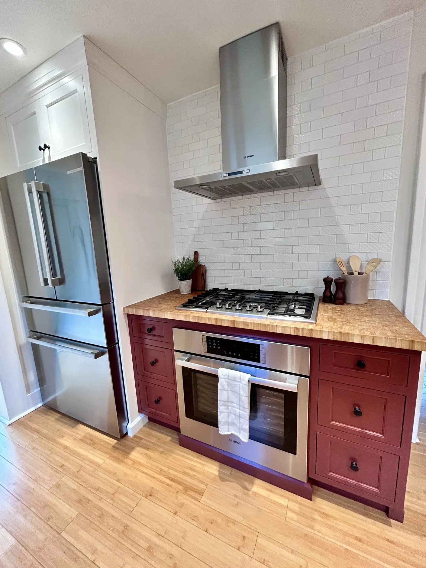 Kitchen range with red cabinets and white tile