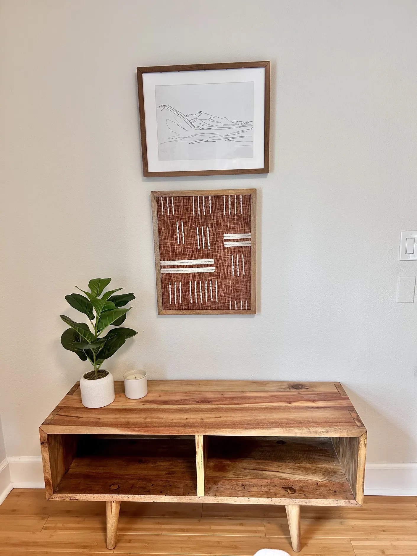 Wood console with plant and framed artwork