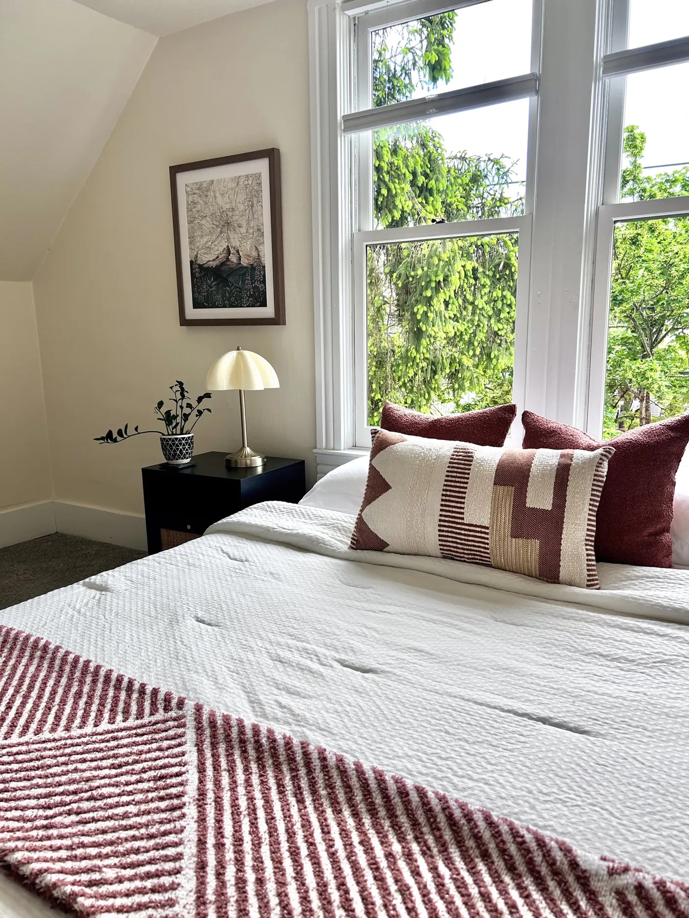 Bedroom with white bedding and burgundy pillows