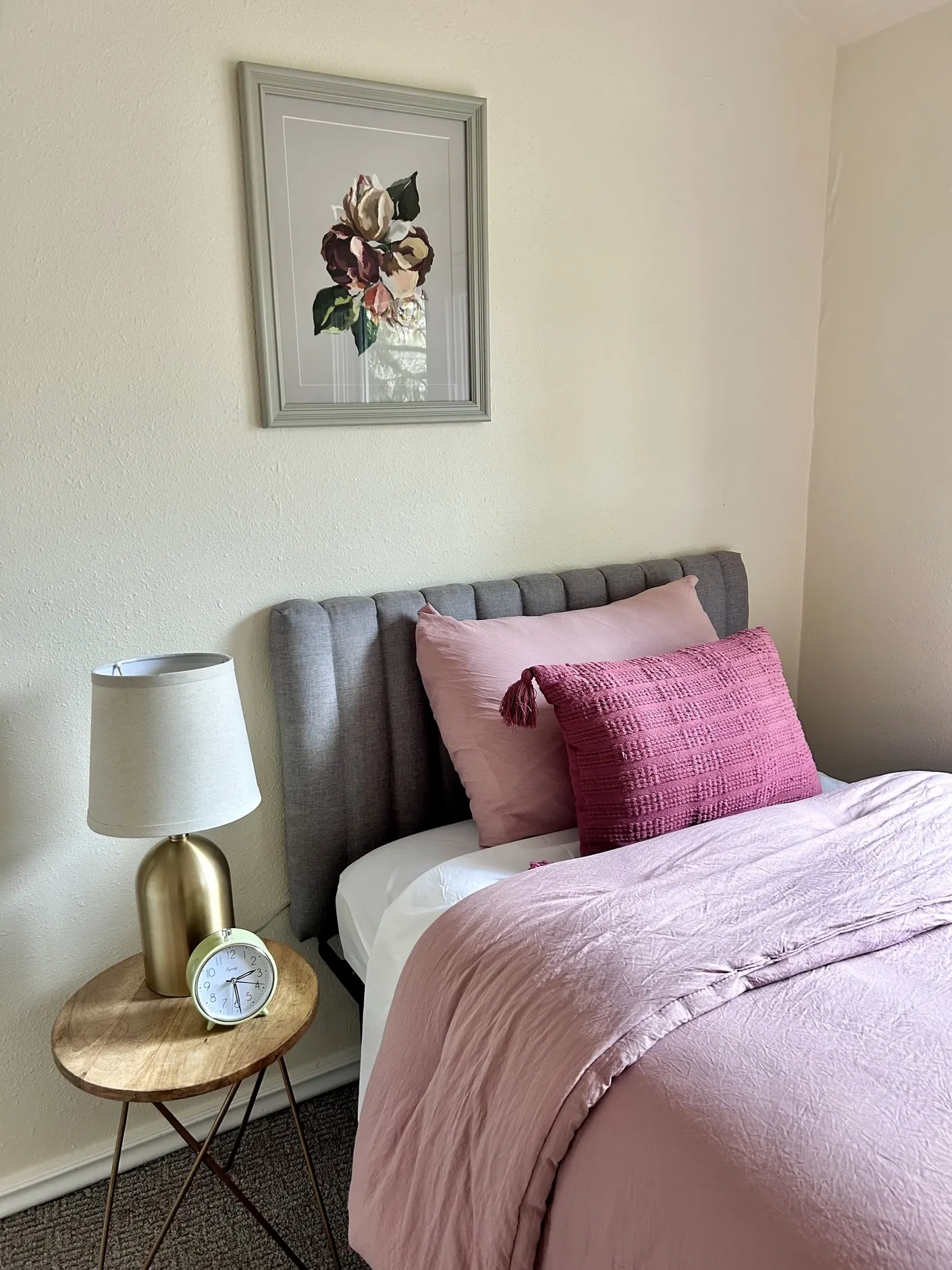 Bedroom with pink bedding and floral artwork