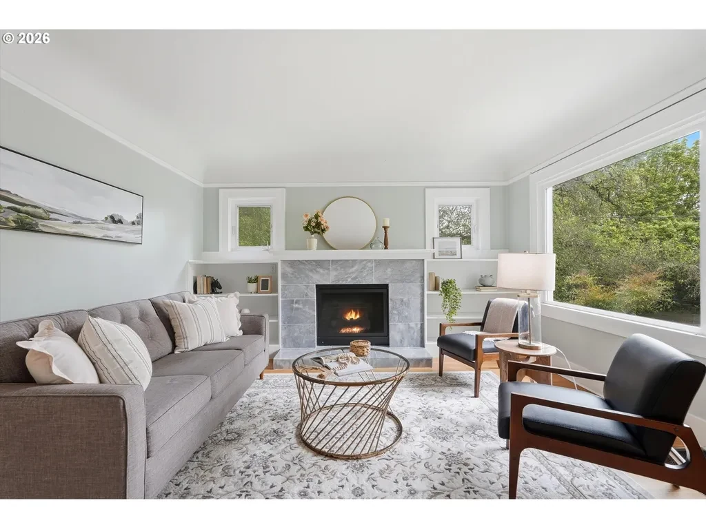 Staged Portland living room with gray sofa, black leather chairs, and fireplace
