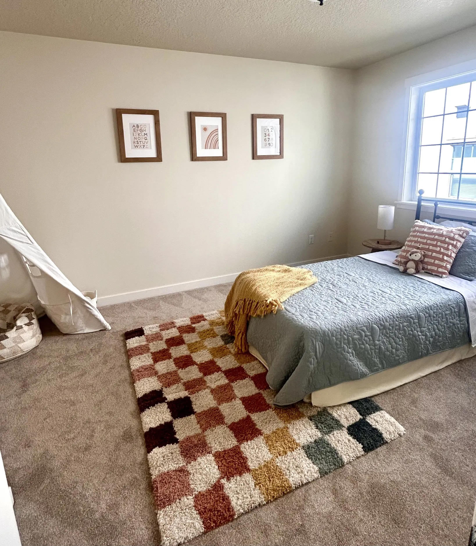 Child’s bedroom with colorful rug and layered bedding