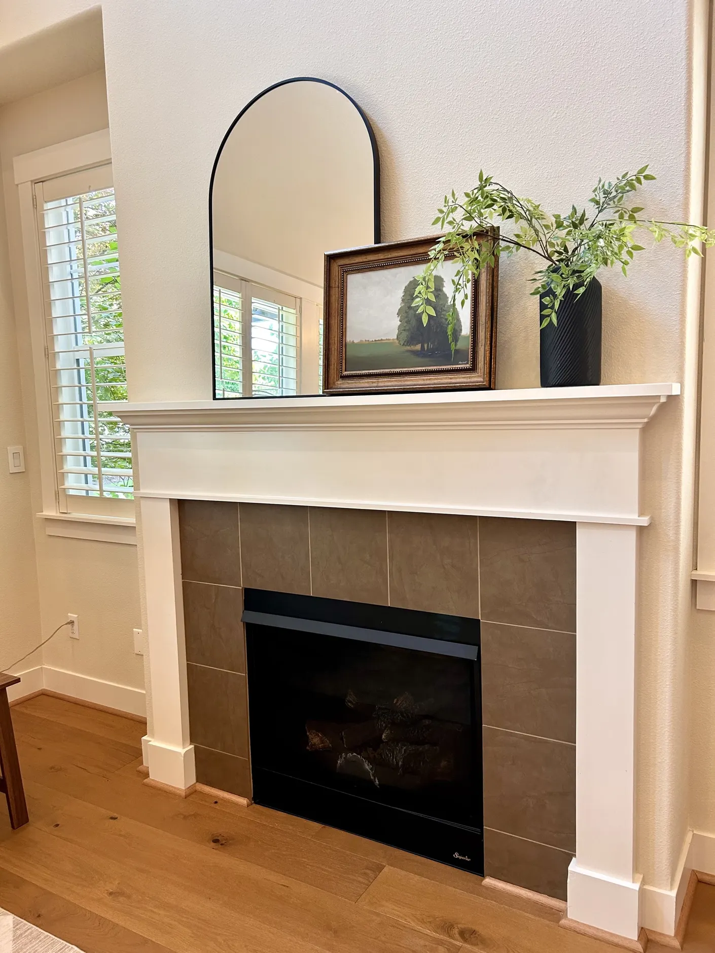Fireplace mantel with mirror and framed artwork